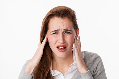 The image shows a woman with her hand on her head, appearing to be in disbelief or shock.