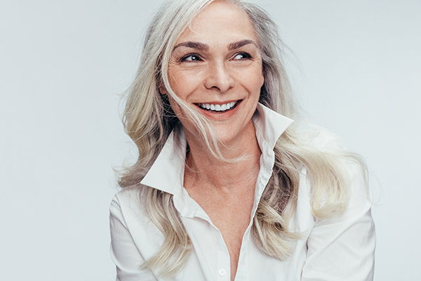 The image features a woman with short hair smiling at the camera.